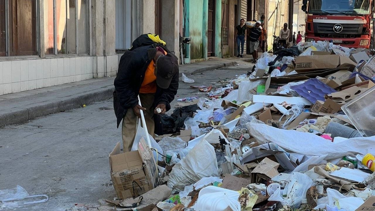 Un hombre busca en la basura en La Habana.