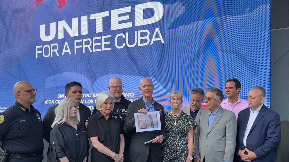 El senador Rick Scott (c) con la foto del exprisionero político cubano Alexander Díaz.