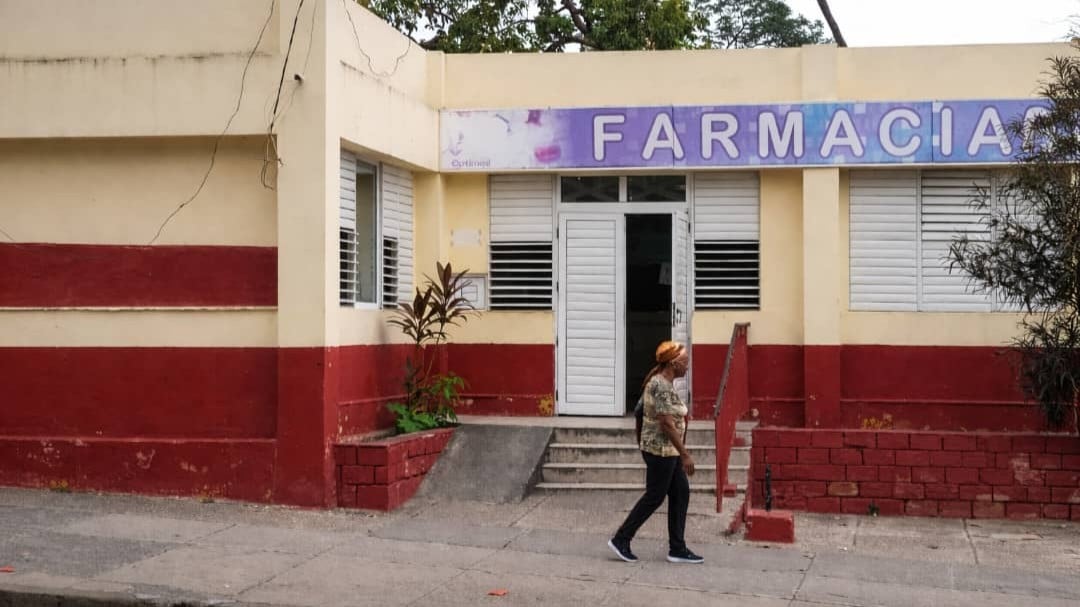 Una mujer frente a una farmacia en Santiago de Cuba.