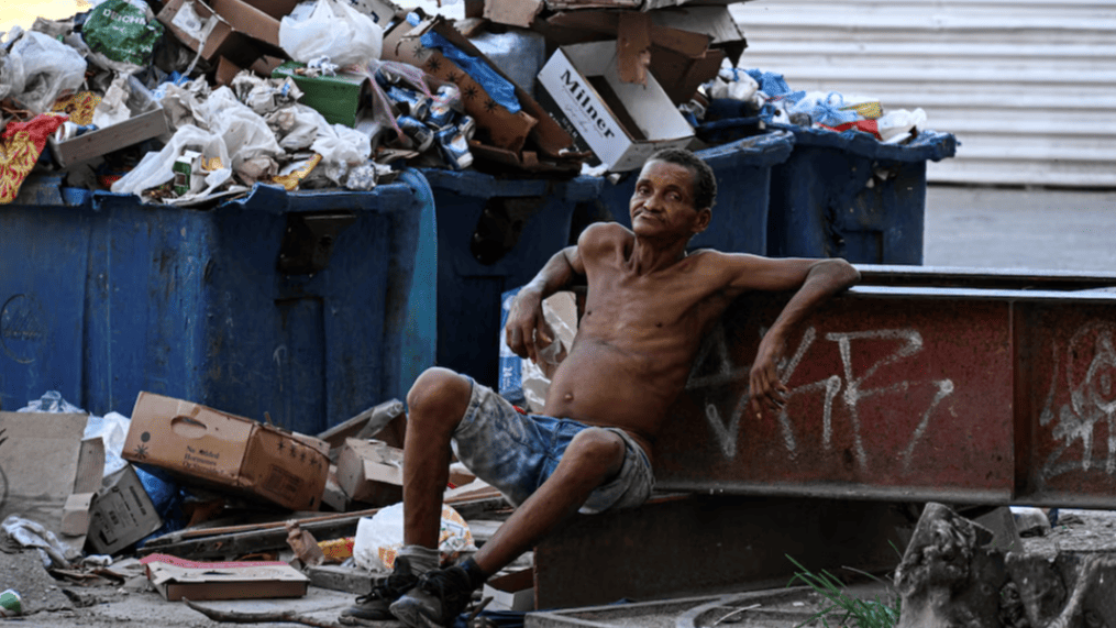Un hombre junto a depósitos de basura en La Habana.