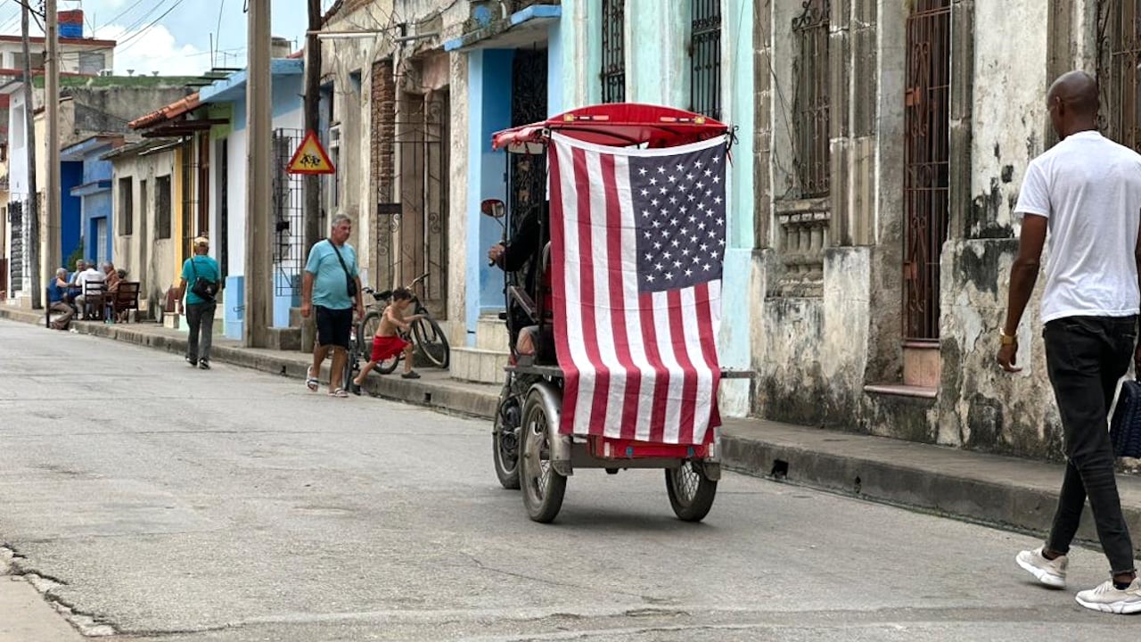 Un bicitaxi con una bandera estadounidense en una calle de Camagüey.