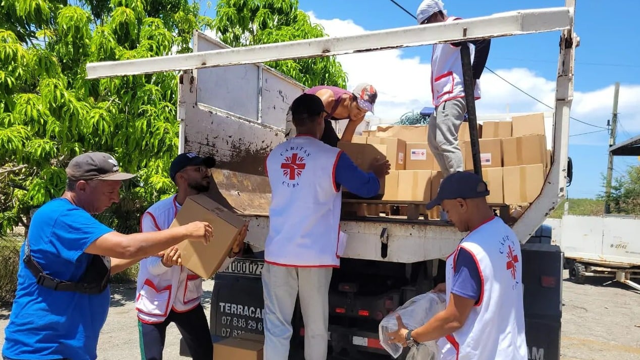 Voluntarios de Cáritas cargan la ayuda humanitaria de EEUU.