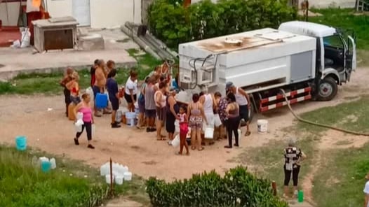Residentes en Boca Camarioca se abastecen de agua con una pipa.