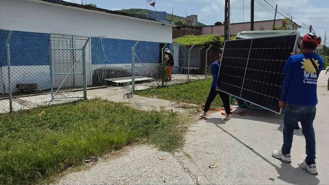 Trabajadores cargan los paneles solares para la radiobase de ETECSA.