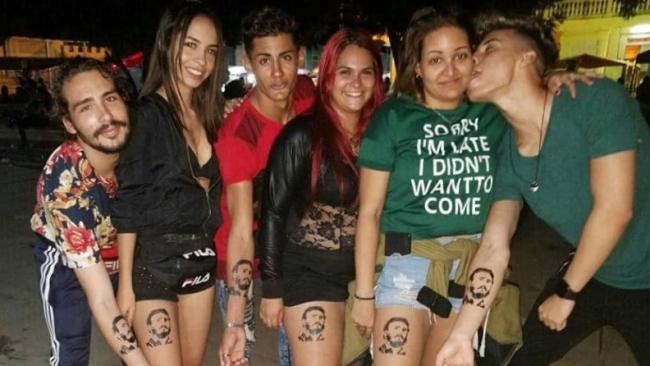 Jóvenes cubanos con una imagen de Fidel Castro en la piel.
