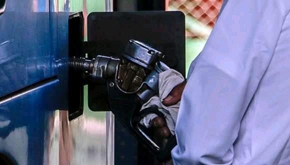 Un chofer llena el tanque de gasolina.