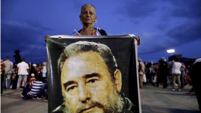 Una mujer con un cartel de Fidel Castro. 