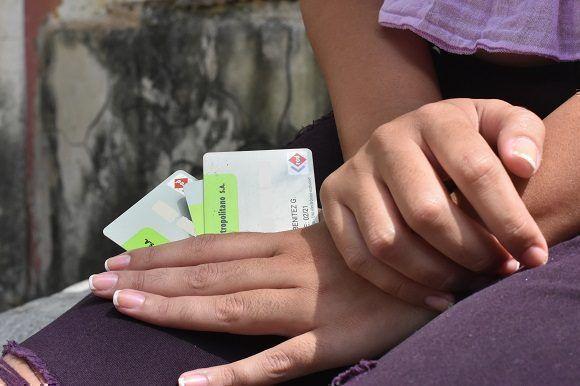Una mujer sostiene tarjetas emitidas por el Banco Metropolitano de Cuba. 