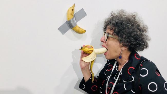 La crítica de arte Elvia Rosa Castro se come un plátano frente a la obra de Cattelan. 