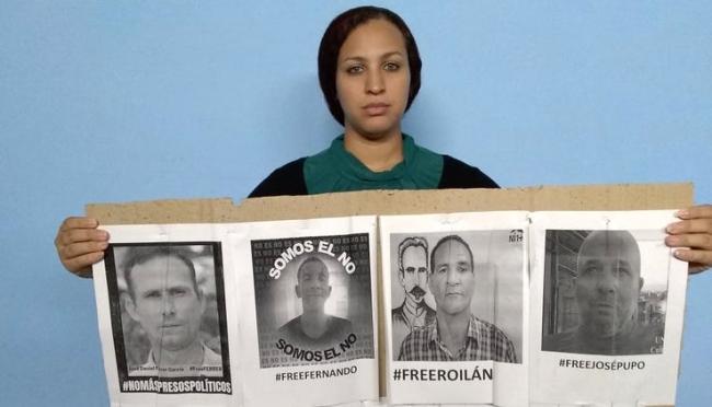 Nelva Ortega, esposa de José Daniel Ferrer, con las fotos de los cuatro detenidos.