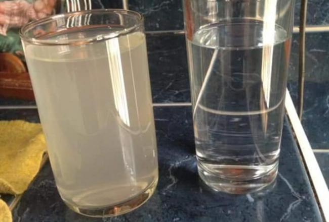 Un vecino de La Lisa compara un vaso del agua recibida este fin de semana (izq) con un vaso de agua limpia.