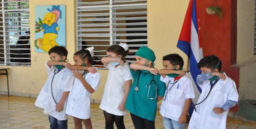 Niños en escuela cubana reciben indicaciones ante el Covid-19.