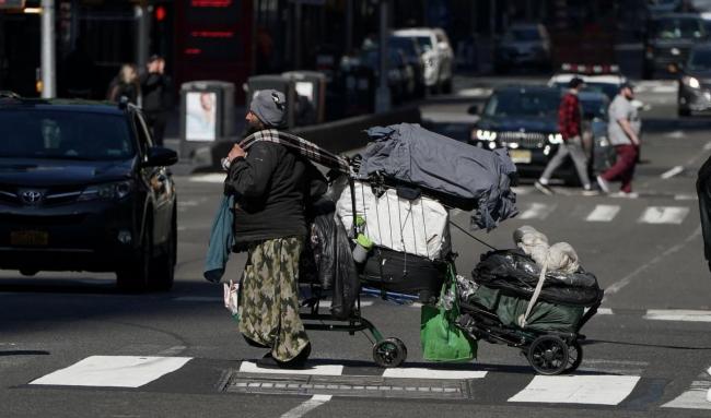 Un vagabundo cruza una calle en Manhattan, Nueva York.