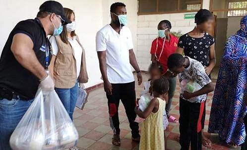 Varios migrantes reciben el donativo de la OIM.