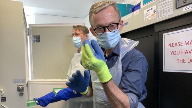Un científico del instituto de Oxford sostiene un vial de la vacuna contra el Covid-19.
