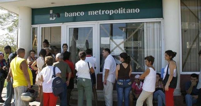Clientes a la entrada de un banco en La Habana.