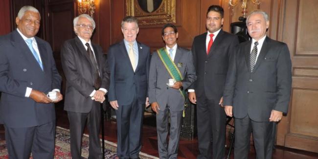Iván Mora Godoy, con banda verde, junto al expresidente de Colombia Juan Manuel Santos.
