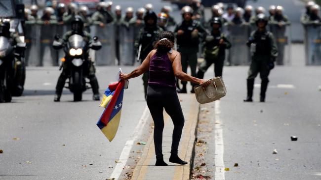 Una mujer planta cara a la policía del régimen de Maduro en manifestaciones de 2017.