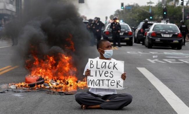 Un manifestante con una pancarta donde se lee 'las vidas negras importan'.