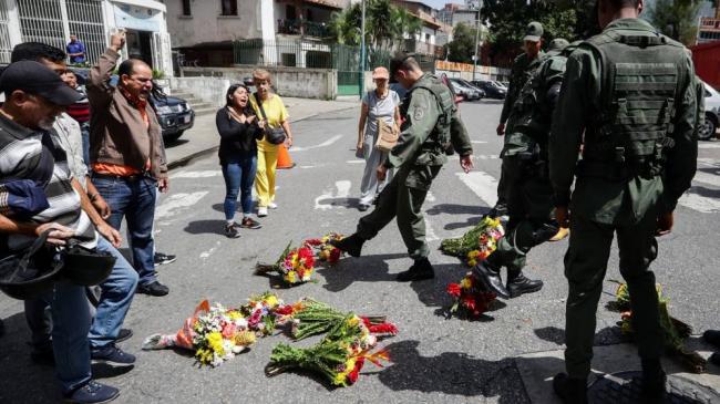 Militares patean ofrendas florales en recuerdo del capitán de corbeta Rafael Acosta, víctima de tortura. (EFE)