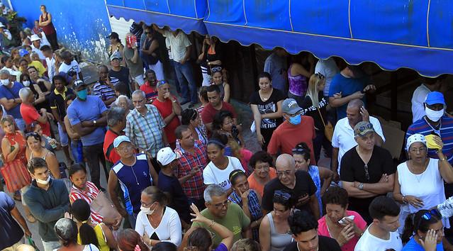 Una multitud de cubanos amontonados en una cola.