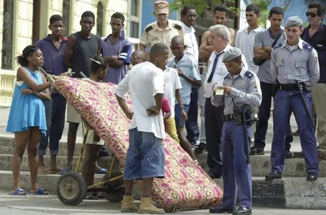 Policías interceptan al portador de un colchón en La Habana Vieja.