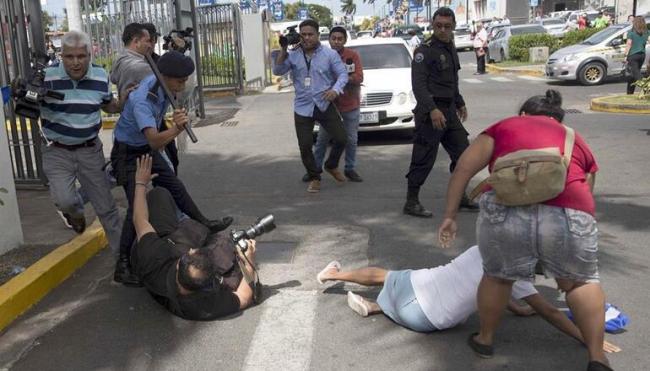 Un agente de la policía nacional de Nicaragua golpea al fotógrafo del diario 'La Prensa' Oscar Navarrete, durante una protesta en Managua en diciembre de 2019.