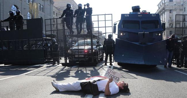 Una mujer, tendida frente a las fuerzas de seguridad con un cartel que dice 'No tengo miedo'