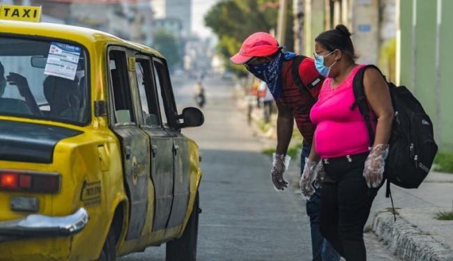 Dos cubanos toman un taxi.