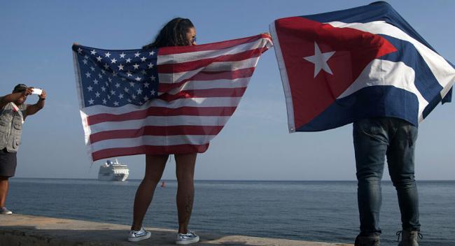Cubanos en La Habana con las banderas de EEUU y la Isla.