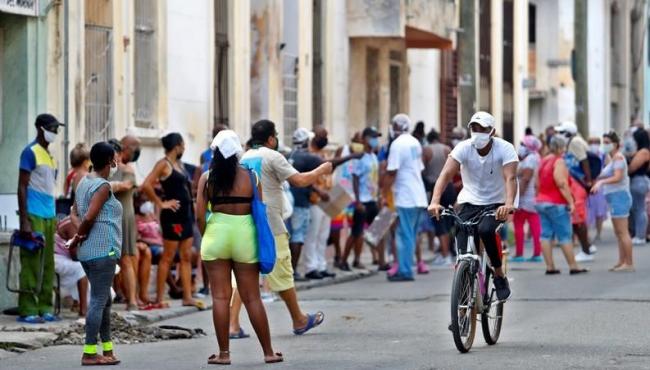 Cubanos hacen colas para abastecerse de alimentos.