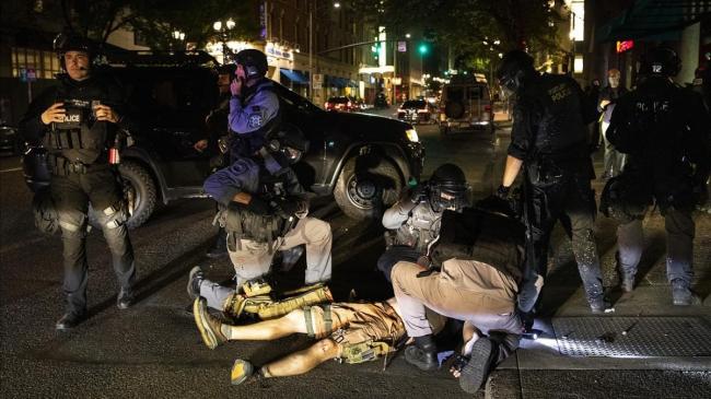 El cuerpo del hombre fallecido por disparos el sábado en Portland yace en el suelo rodeado de policías.