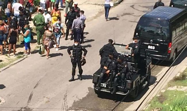 Oficiales de los llamados Boinas Negras controlan una cola en Cuba.