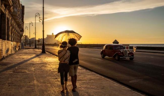 Una pareja camina frente al Malecón de La Habana.