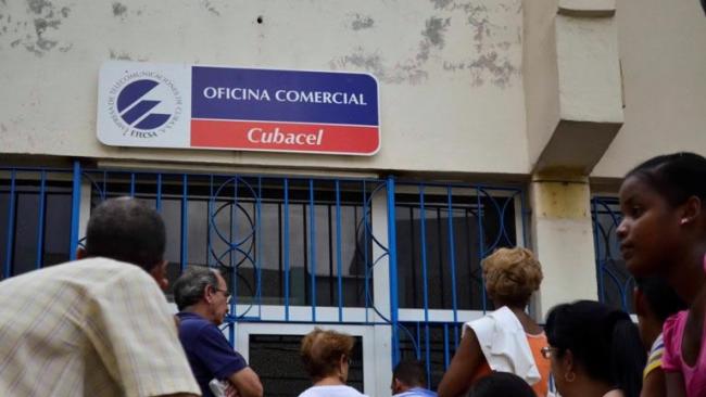 Cubanos hacen cola ante una oficina de ETECSA.