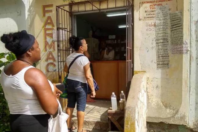 Consultando los medicamentos tachados y no tachados en el listado de una farmacia en Santiago de Cuba.