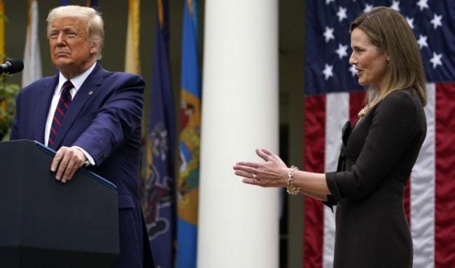 La jueza Amy Conney Barret aplaude cuando el presidente Donald Trump la anuncia como su nominada a la Corte Suprema.