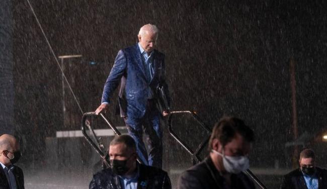 Joe Biden en medio de un aguacero al concluir su mitin de campaña el jueves en Florida.