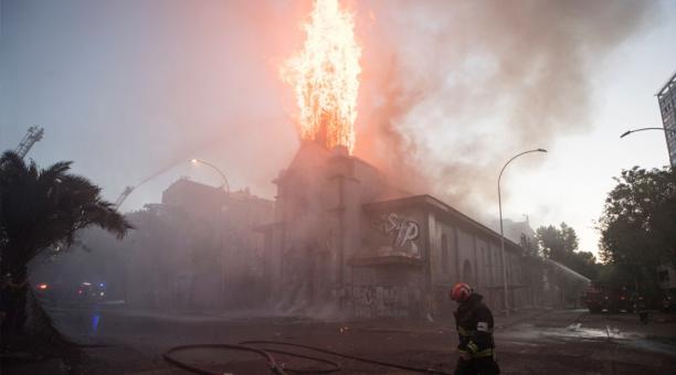 Bomberos trabajan en la extinción del incendio de la parroquia de la Asunción este domingo en los alrededores de la Plaza Italia de Santiago.