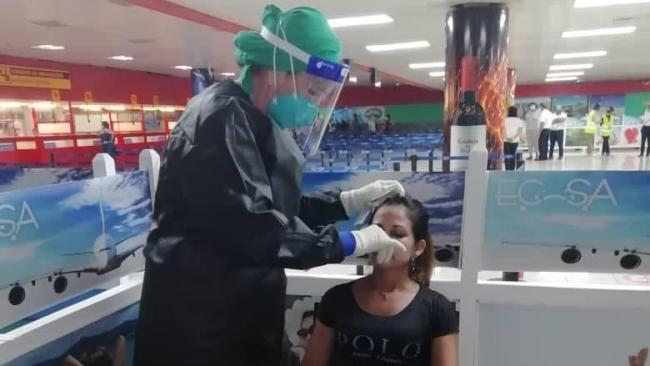 Enfermera hace prueba a cubana en el aeropuerto de La Habana.