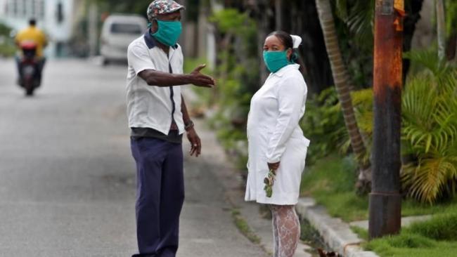 Una enfermera conversa con un anciano en Cuba.