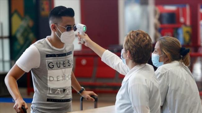 Médicos cubanos toman la temperatura a un joven.