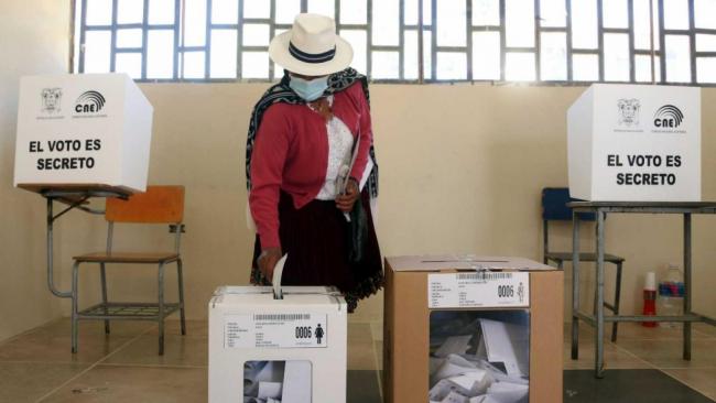 Una persona deposita su voto durante las elecciones de Ecuador.