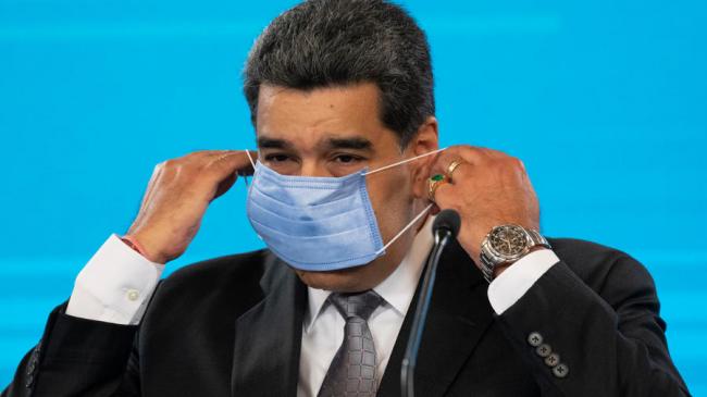 Nicolás Maduro se coloca la mascarilla durante la conferencia de prensa. 