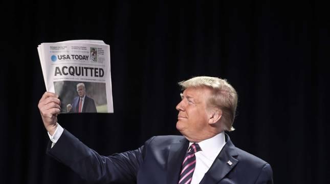 Donald Trump sostiene un periódico con una portada dedicada a él.