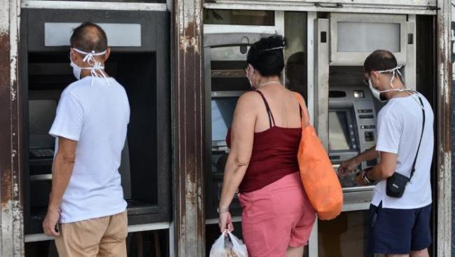 Cubanos realizan operaciones en cajeros automáticos.