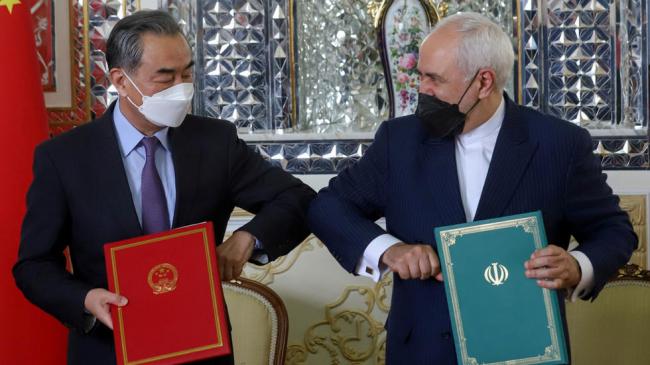 El ministro de Asuntos Exteriores de Irán, Mohammad Javad Zarif, y el ministro de Asuntos Exteriores de China, Wang Yi, chocan los codos.