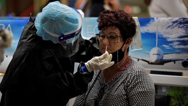 Una mujer es sometida a una prueba PCR a su llegada a Cuba.
