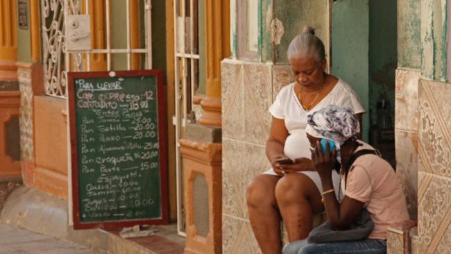 Cubanas junto a una cafetería en La Habana.
