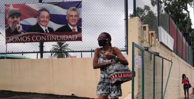 Una mujer pasa frente a un cartel en La Habana.